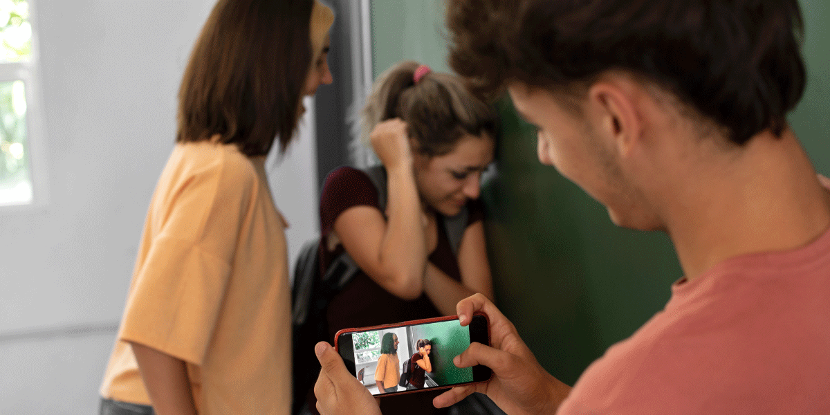 Boy taking a video of a girl bullying another girl