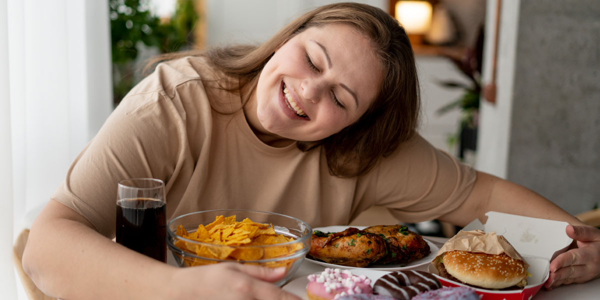 Girl hugging plates of processed foods