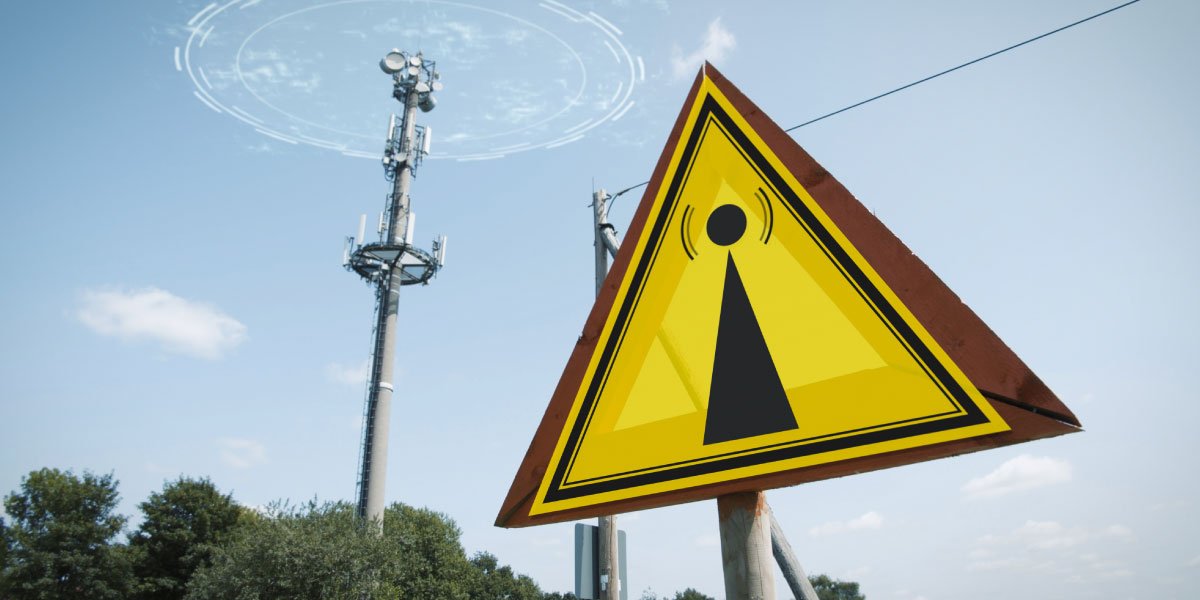 EMF warning sign and a 5g tower causing radiation under a blue sky