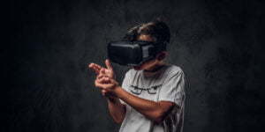 Little boy using a VR headset and holding his hand like a gun