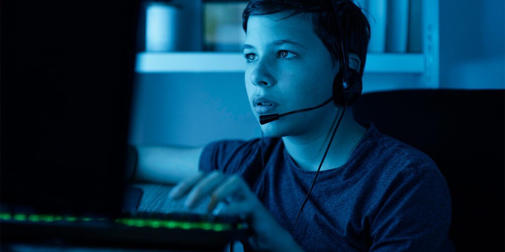 kid wearing headsets while using computer