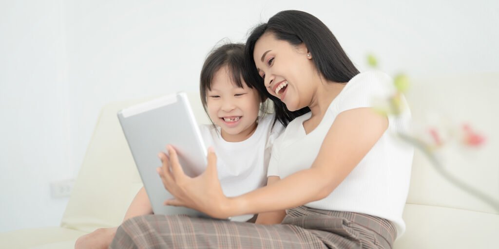 Child and parent watching a tablet screen together