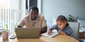 a father learning how to disable internet on child’s phone with his daughter sitting next to him