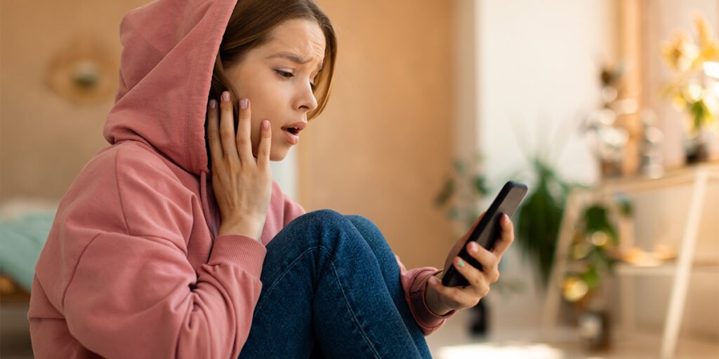 Shocked teen girl on cellphone