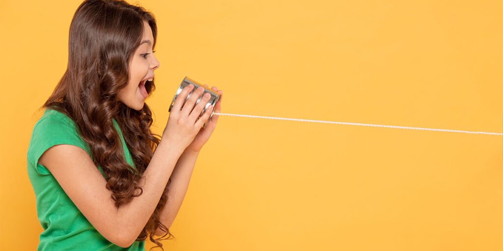 A girl is screaming into a can tied to a rope