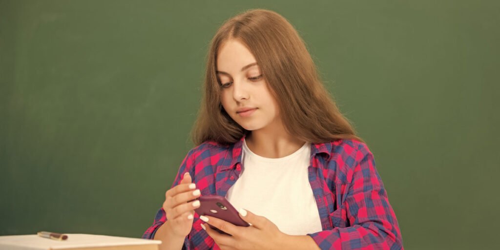 Caucasian girl using her phone with her mom installing the best porn blocker for Android