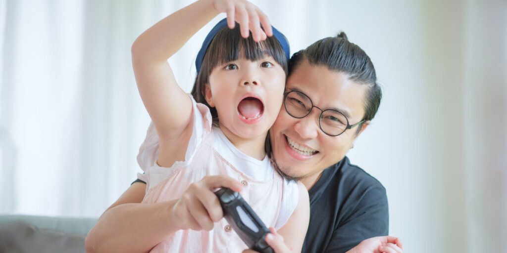 Father and child play PS5 together
