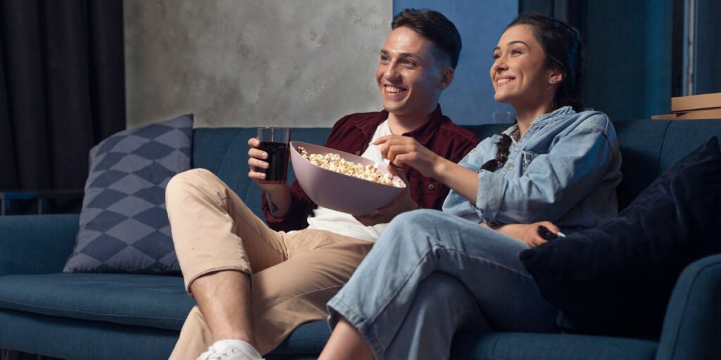 a couple sitting on the couch and wondering how to put parental control on TCL TV