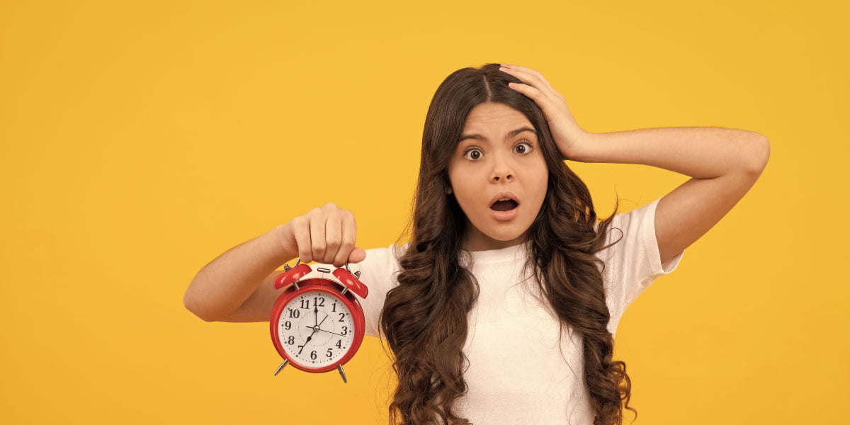 A teenage girl holding a clock, worried about her screen time running out