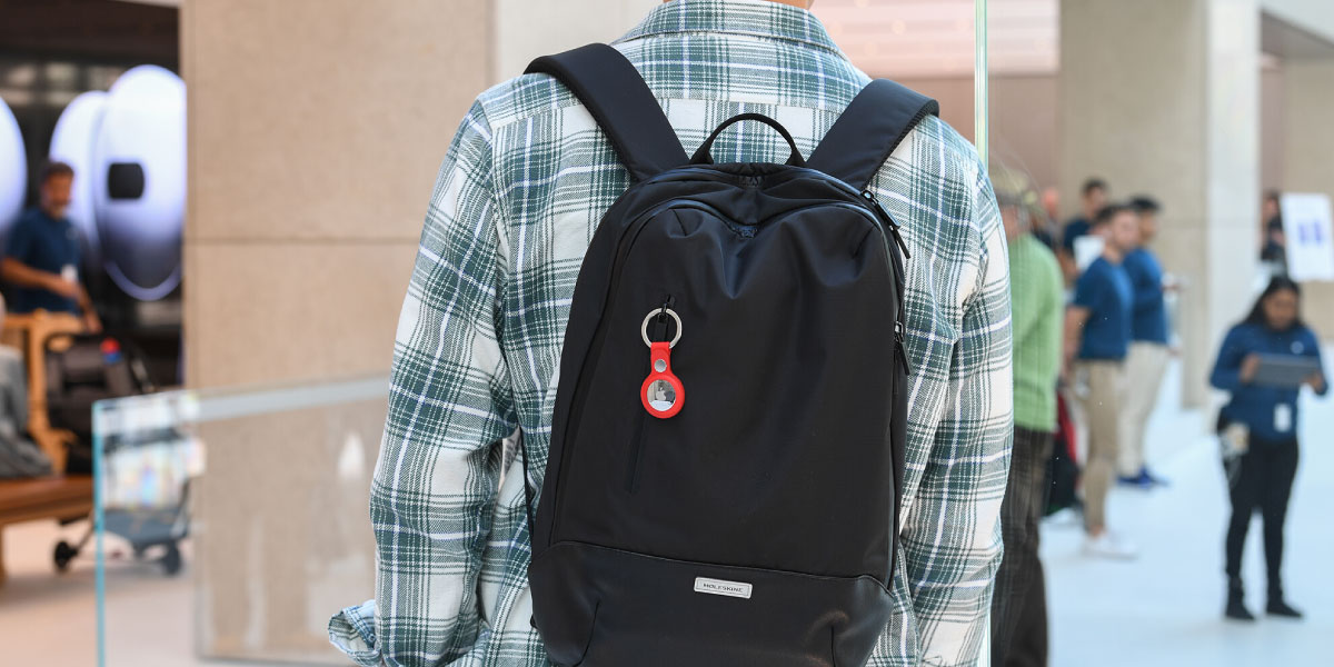 Ein Schuljunge mit einem Apple AirTag auf seinem Rucksack]