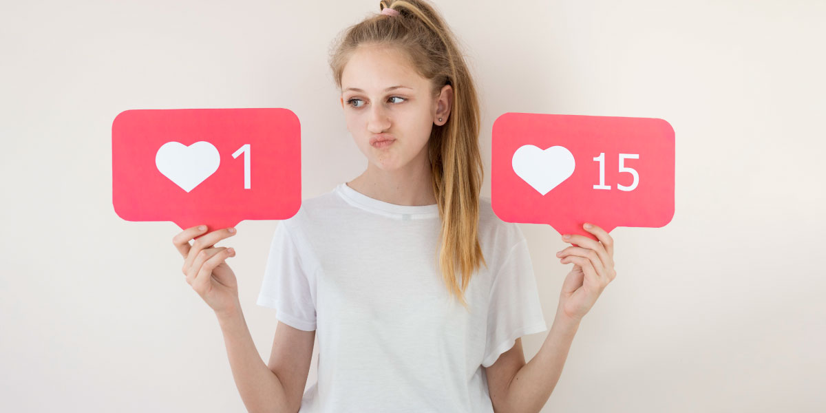A disappointed teenage girl, comparing the one like she got on social media to someone else’s fifteen likes