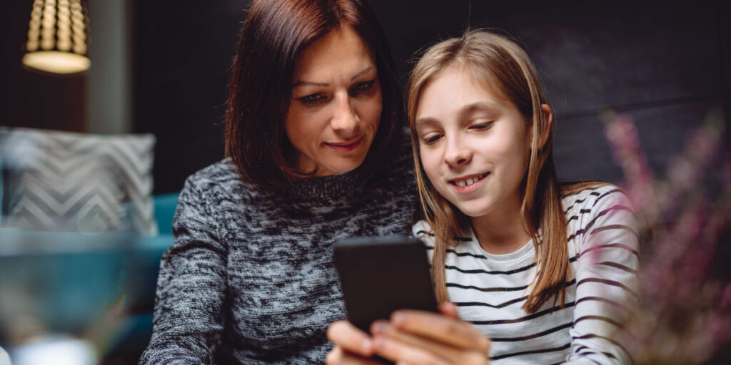 Teenager showing their phone to their parent