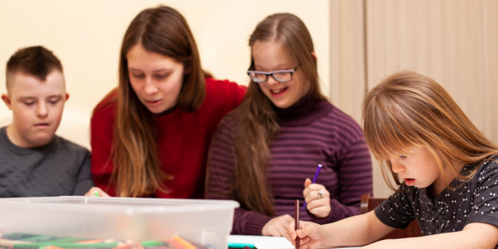 kids with special needs sitting around a table coloring