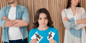 Porträt von Eltern und Kind, die eine zerrissene Zeichnung der Familie halten