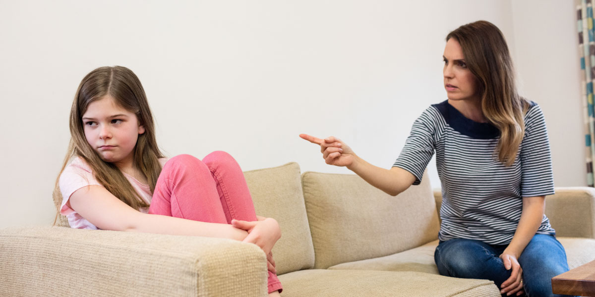 Parent berating child on a sofa