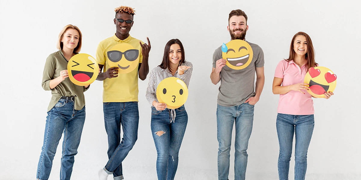 Group of friends holding emojis in their hands