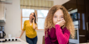 Sad girl and mom talking on the phone