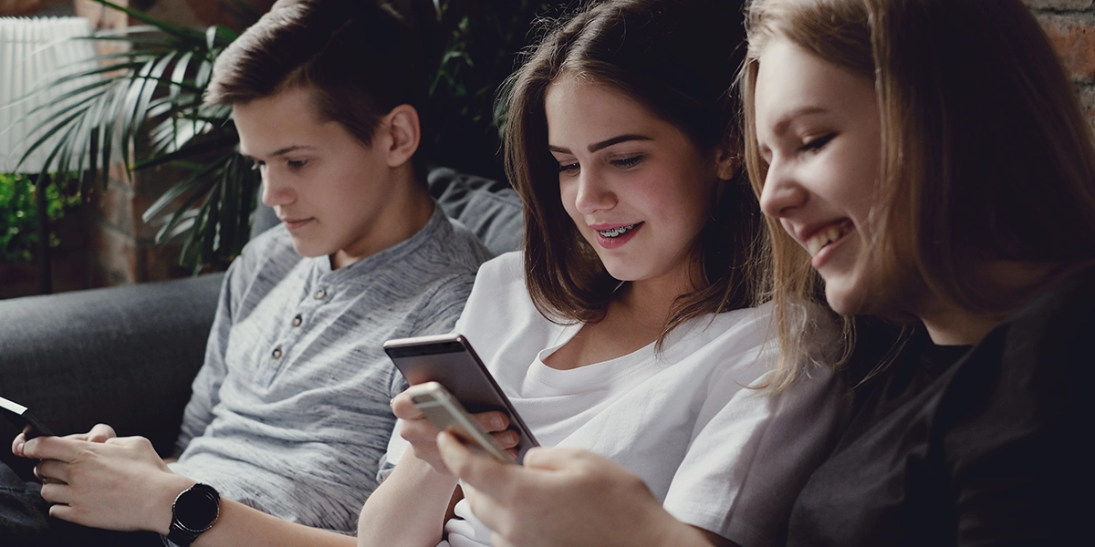 three teenagers using their smartphones