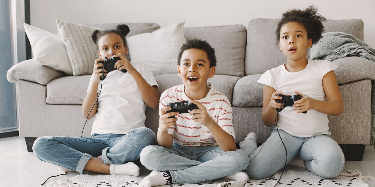 2 girls and a boy playing with a game console