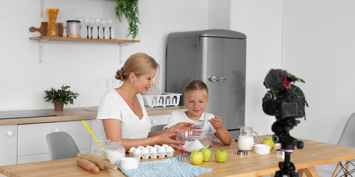 Mom baking with her daughter in front of a camera