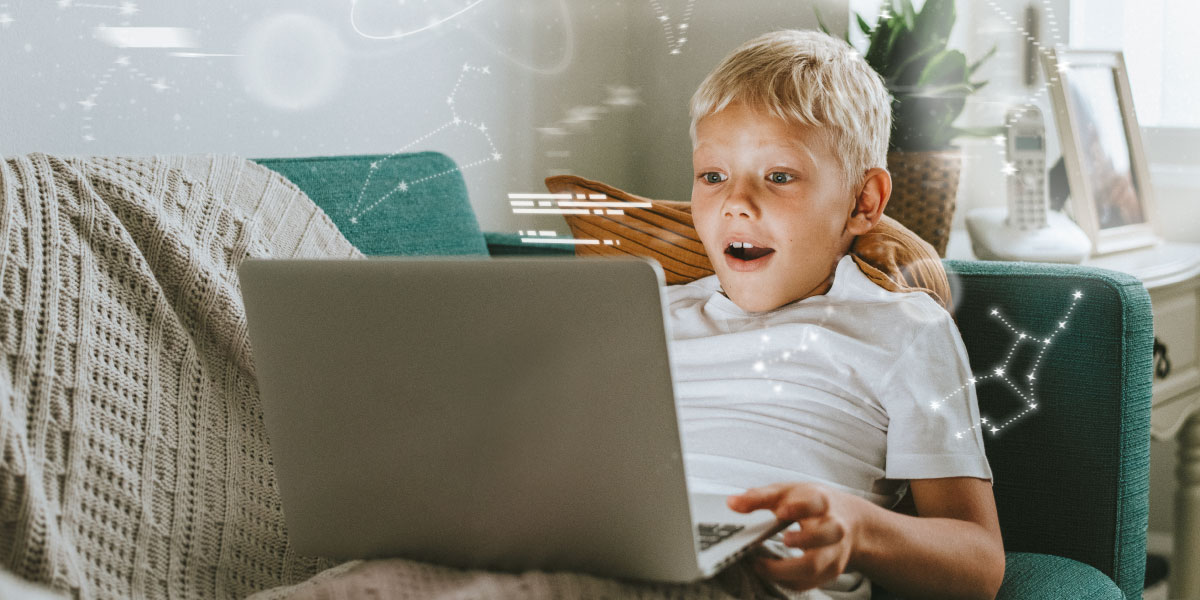 Kind sitzt auf einer Couch mit einem Laptop auf dem Schoß und Sternzeichen, die aus dem Laptop kommen
