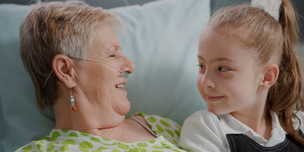 Young girl and grandmother looking at each other in hospital