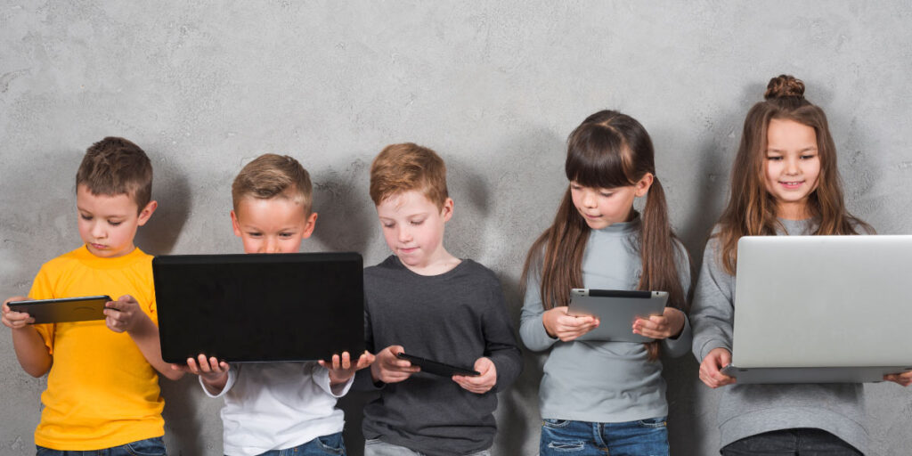 5 Kinder stehen und benutzen elektronische Geräte