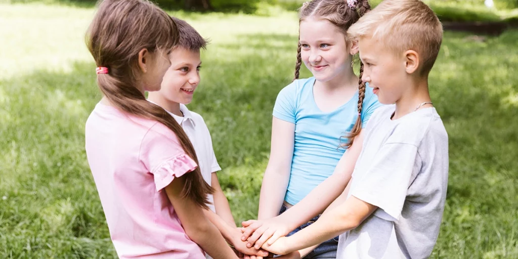 Four children forming a heart with hands