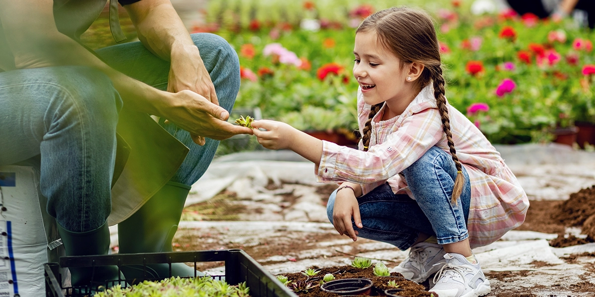 girl gardening with parent