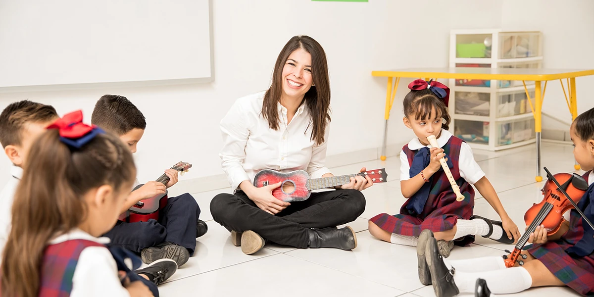 Teacher teaching music to a group of preschool pupils