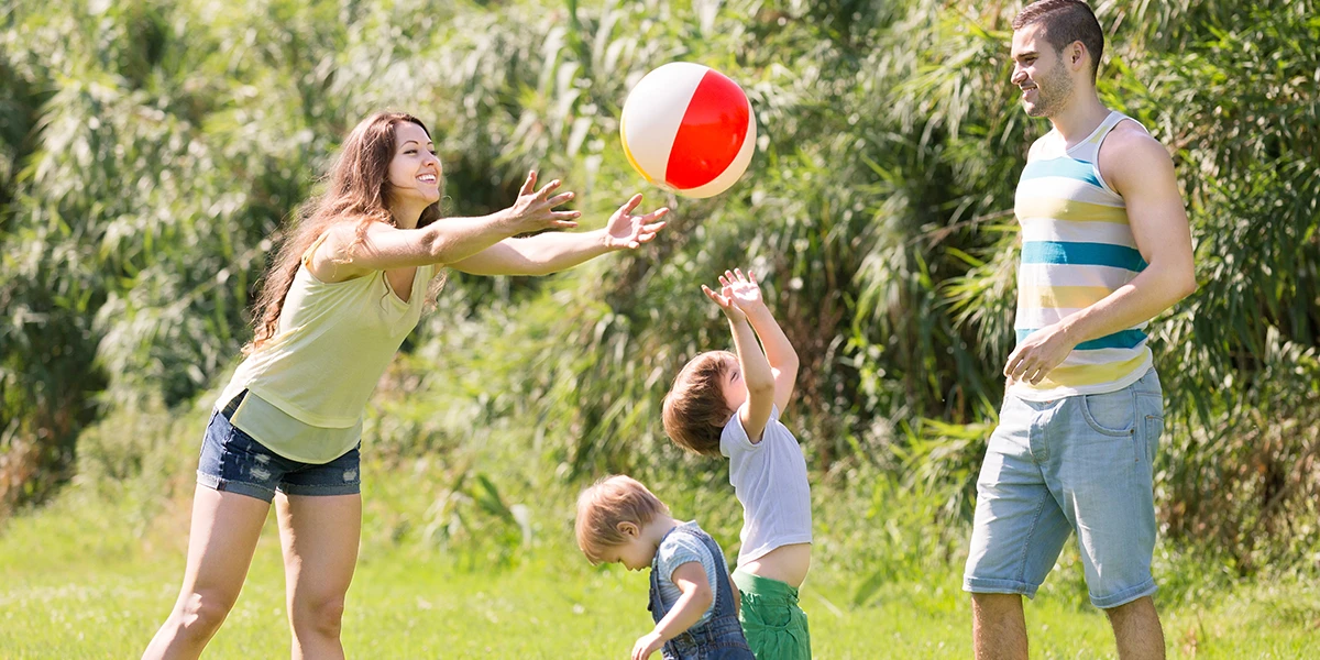 Eltern und Kinder spielen Ball im Freien