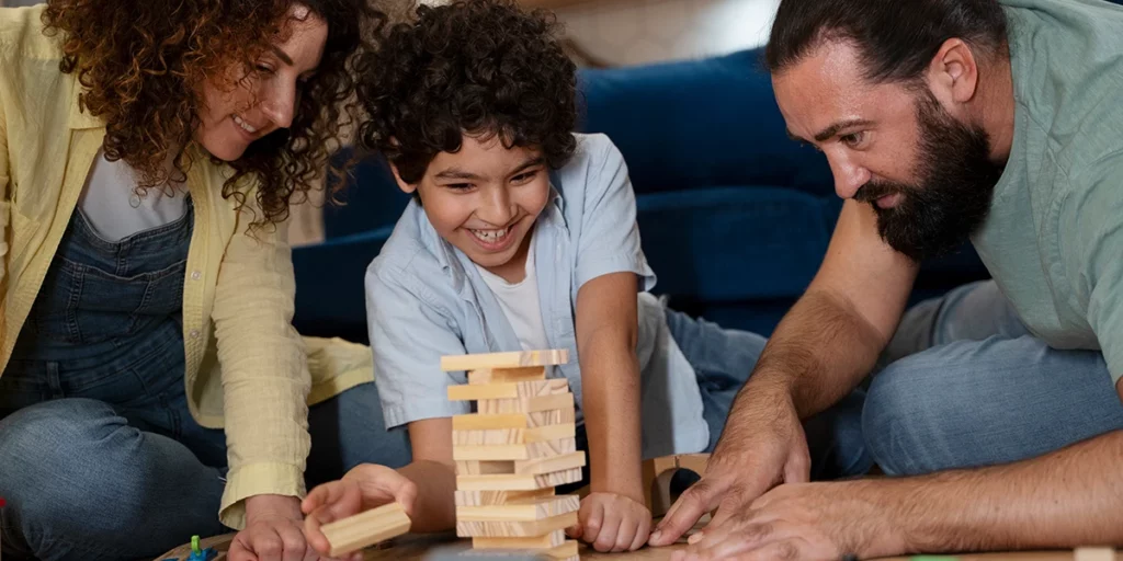 Boy playing Jenga with parents