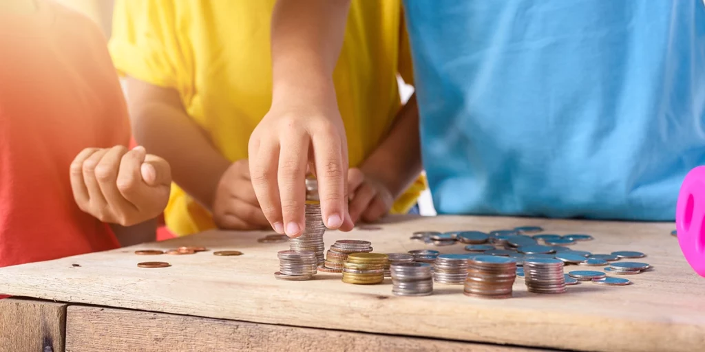 Children playing a budgeting game with coins