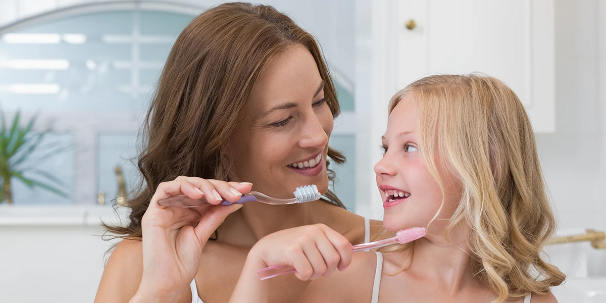 Mutter und Tochter putzen sich die Zähne
