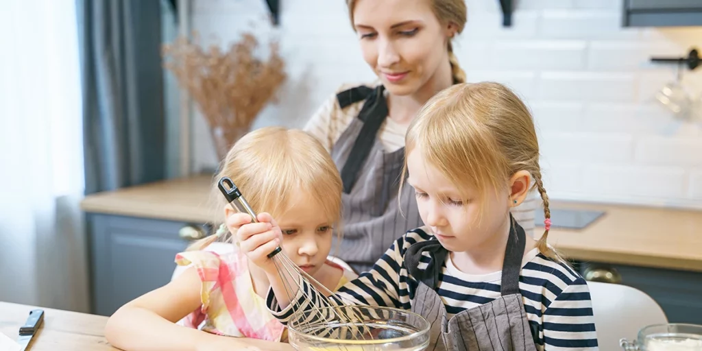 mother cooking with her two daughters