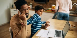 Junge kämpft um die Aufmerksamkeit seiner Eltern, Vater telefoniert und Mutter in der Küche