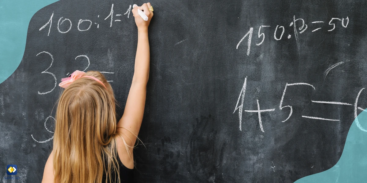 Elementary schooler doing math on a blackboard