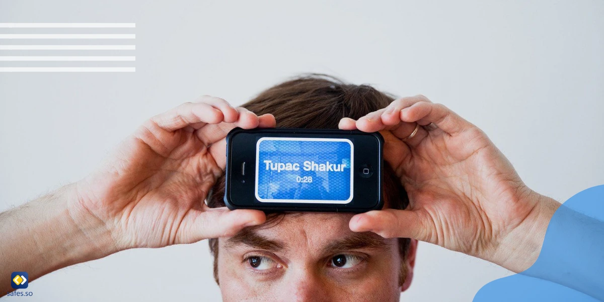 Mann hält sein Telefon an die Stirn, während die Heads Up-Spiele-App geöffnet ist und eine Wortkarte anzeigt