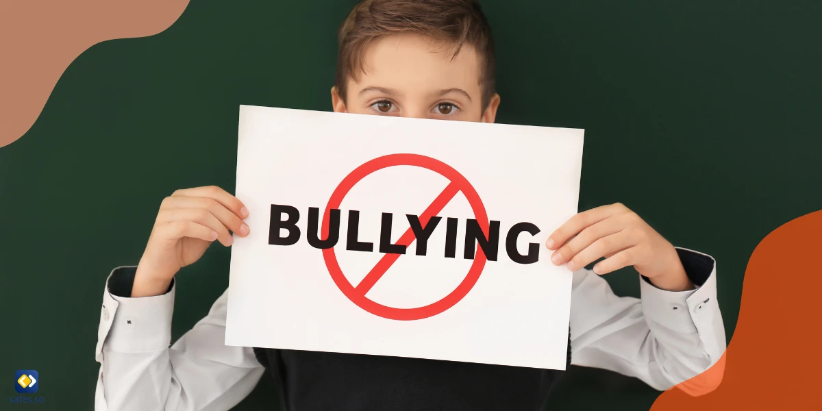 Schüler hält ein Schild "Stoppt Mobbing" vor der Tafel des Klassenzimmers.