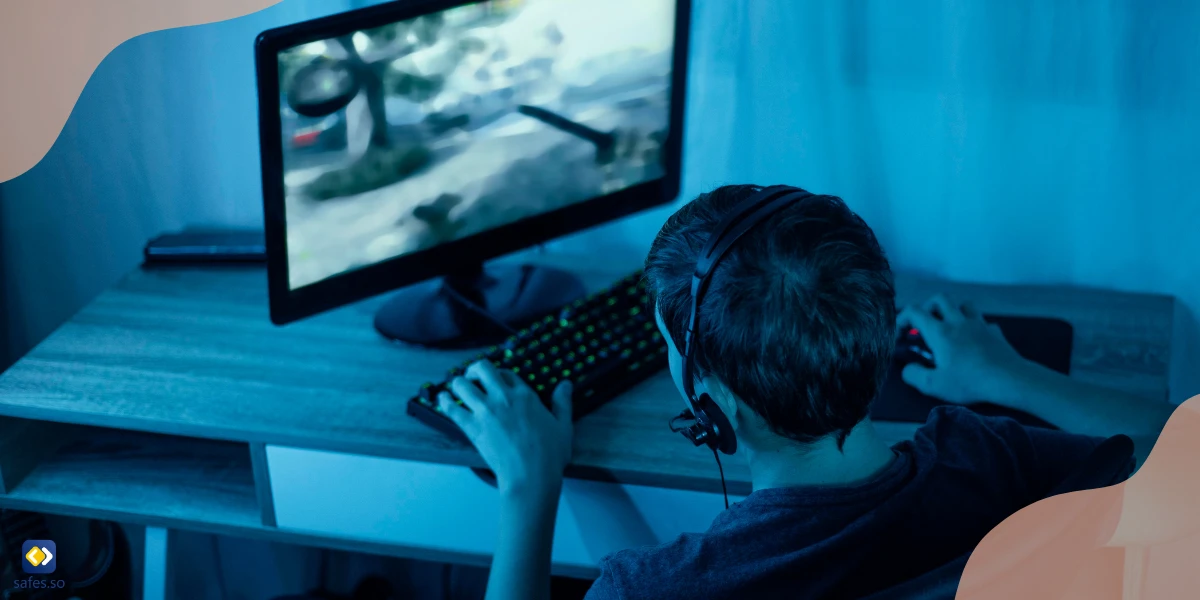 Young boy playing video games on a computer alone in a dark environment