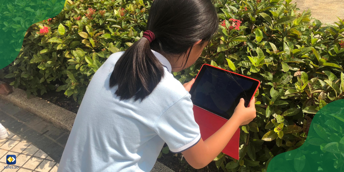 Studentin, die Seek by iNaturalist auf ihrem Tablet verwendet, um die Art einer Pflanze zu identifizieren