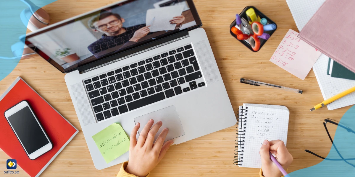 girl taking notes while watching an online class