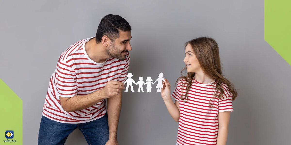 Vater und Tochter halten ein Origami von Familienmitgliedern