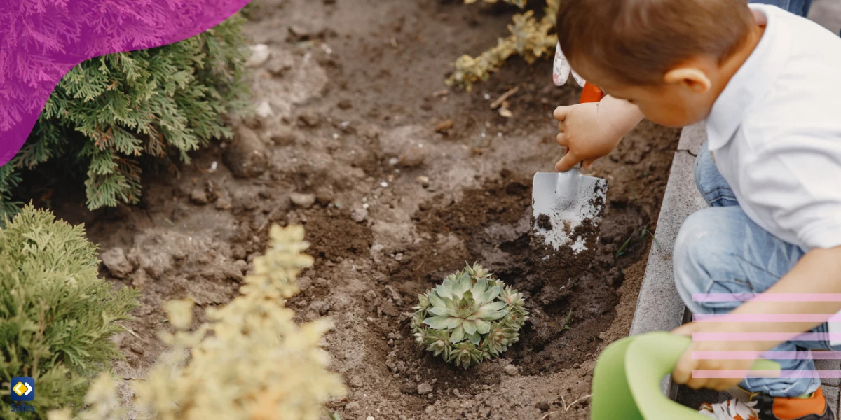 Kindergärtnerin pflanzt eine Pflanze im Garten
