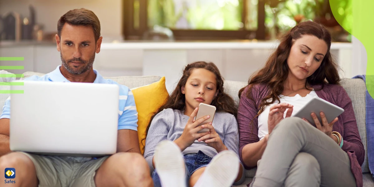 Familie mit verschiedenen Geräten auf einem Sofa