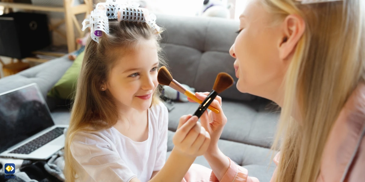 Mother and daughter doing make up for each other