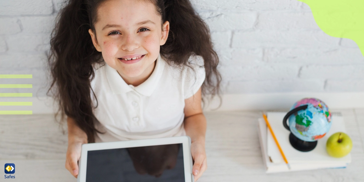 A happy girl is sitting on the floor with a tablet in her hand