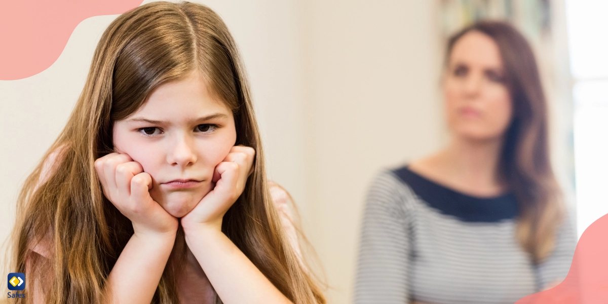 An upset little girl is sitting with her mom