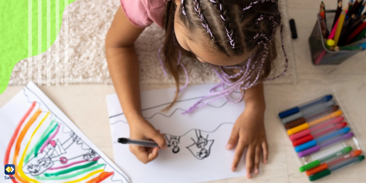 Kind zeichnet mit Buntstiften auf Papier