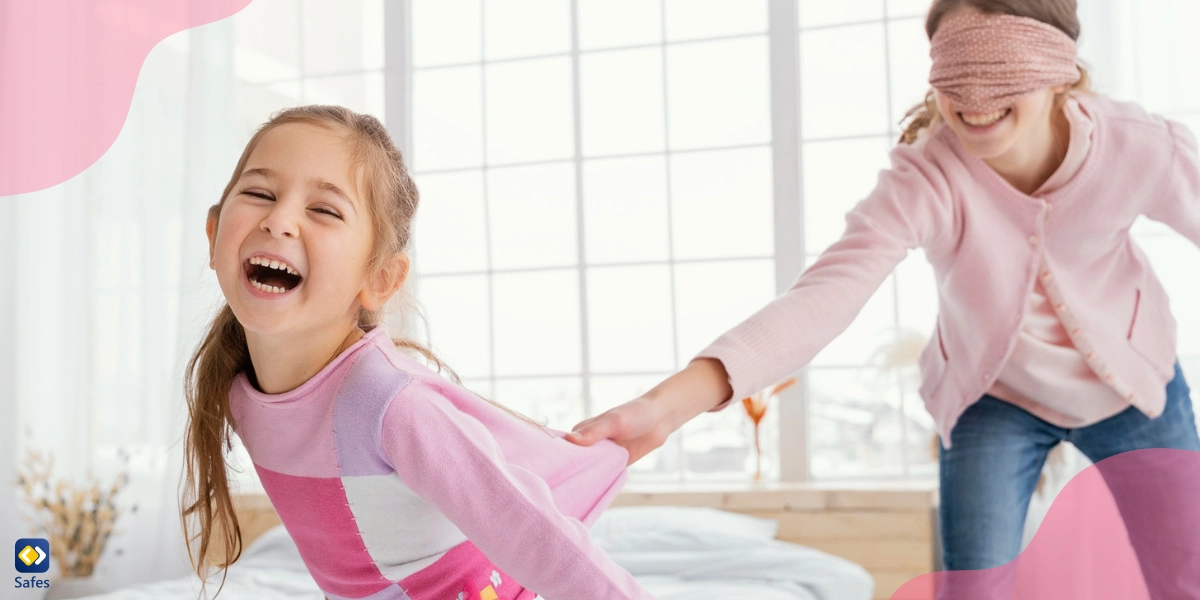 Older blindfolded sister pulling sister’s shirt while laughing